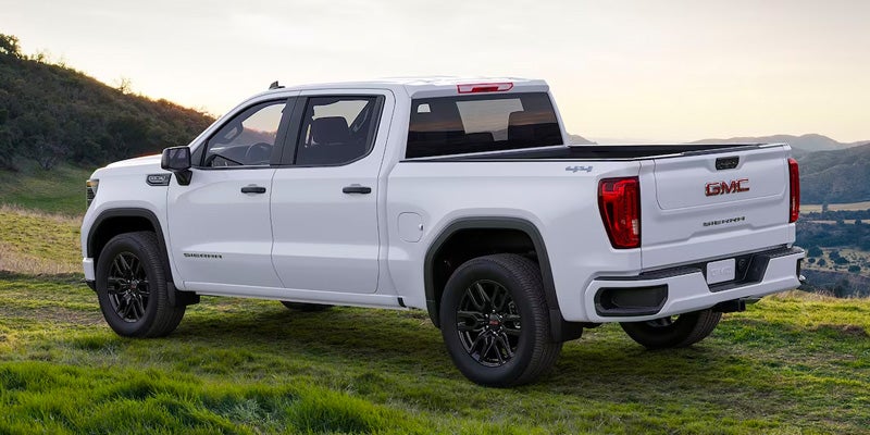 An all-new White 2024 GMC Sierra 1500 parked among the grassy rolling hills. - Boyd GM Oxford, NC