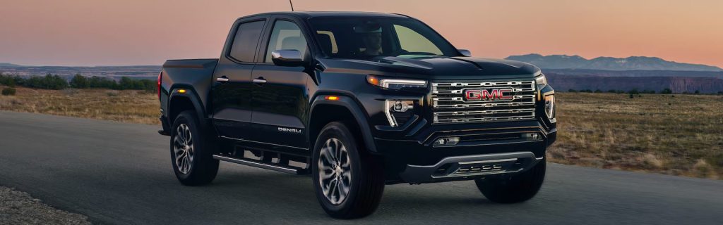 2026 GMC Canyon driving on an open road at sunset