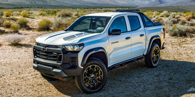 White Chevrolet Colorado parked in a rugged desert landscape.